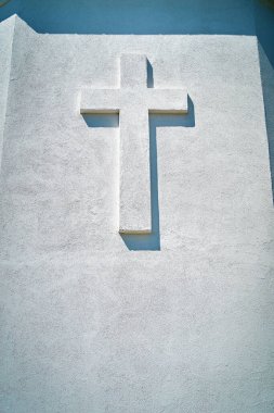 Bir taş haçın dikey fotoğrafı mavi bir gökyüzü arkaplanına karşı