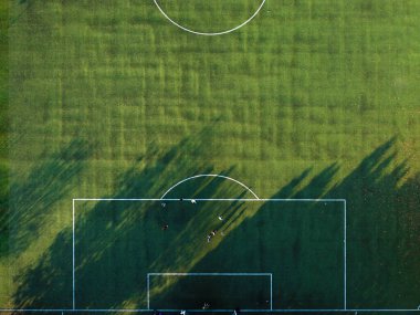 İnsanlar yeşil alanda futbol oynuyorlar.