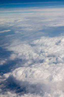 view above clouds from airplane window, above the clouds