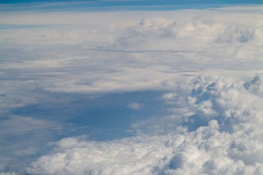 view above clouds from airplane window, above the clouds