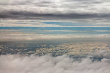 view above clouds from airplane window, above the clouds