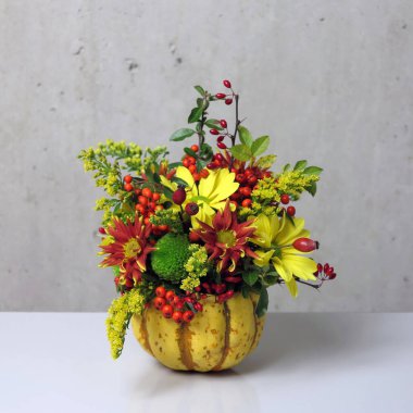 floral arrangements in yellow mini pumpkin, floral decor from lot of various flowers and plants in pumpkin