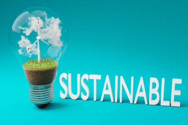 içinde minyatür rüzgar türbini olan tek bir ampul; yeşil toprak ve bulutlar; yenilenebilir enerji konsepti; 3 boyutlu illüstrasyon