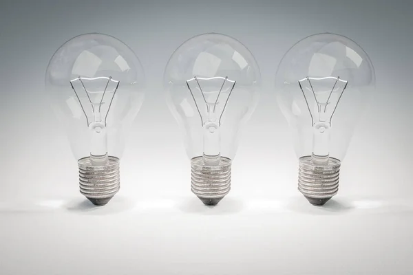 Три Лампочки Ретро Стиле Светящимися Нитями Стоящими Ряд Бесконечном Фоне — стоковое фото