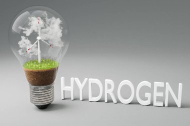 içinde minyatür rüzgar türbini olan tek bir ampul; yeşil toprak ve bulutlar; yenilenebilir enerji konsepti; 3 boyutlu illüstrasyon