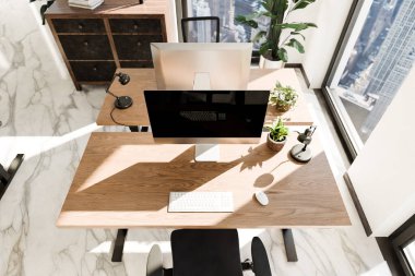 top down perspective of minimalistic pc workspace in luxurious loft office and panoramic view; remote work home office concept; bright daylight; 3D rendering