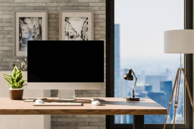 Modern temiz pc işyeri ön görünümü; kopyalama alanı olan siyah monitör; büyük şehir silueti üzerinde panoramik görünümlü minimalist ofis arkaplanı; ev ofis kavramı; 3D görüntüleme