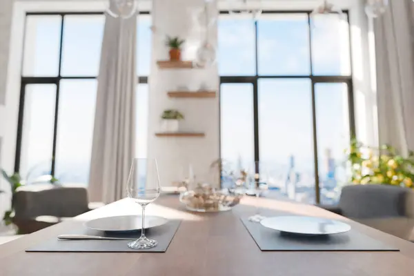 closeup of dining table in luxurious loft with floor-to-ceiling windows and panoramic view; modern minimalistic interior design; bright daylight; 3D rendering