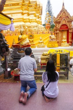 Buddhist worshipping at the gold Temple in Wat Prathat Doi Suthep, Thailand clipart