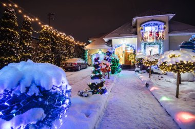 Ev Noel tatili ışıkları ve süslemeleri ile süslenmiş. Noel Baba ve Noel ağaçları gece aydınlatmalı.