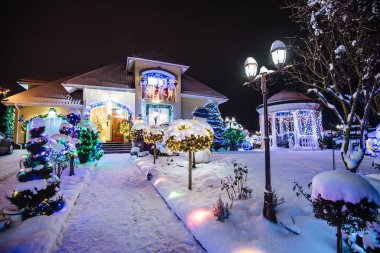 Ev dekore edilmiş ve geceleri Noel için ışıklandırılmış. Noel ışıkları evin dışında.