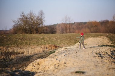 Cute little girl having fun in nature. A beautiful child poses outdoors on a sunny day in early spring.