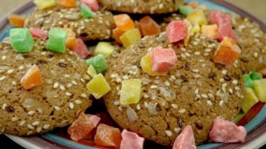 Fresh homemade oatmeal cookies sprinkled with sesame and candied fruit rotate. Simple homemade healthy bakery. Food background. Close up.