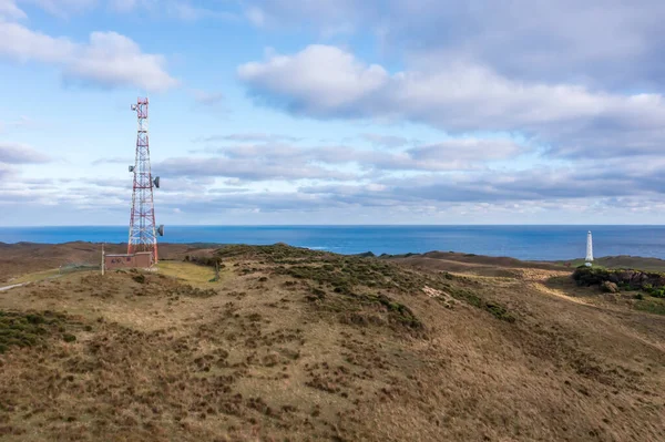 Drone aerial photograph of a large communications tower in a large agricultural field near the coast in Currie on King Island in Tasmania in Australia