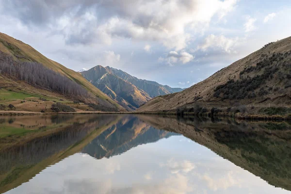 stock image Photograph of Lake Kirkpatrick with mountains reflecting in the water on a cloudy day outside Queenstown on the South Island of New Zealand