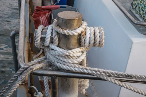 Photograph of white rope wrapped around a steel boat mooring bollard on King Island in the Bass Strait of Tasmania in Australia