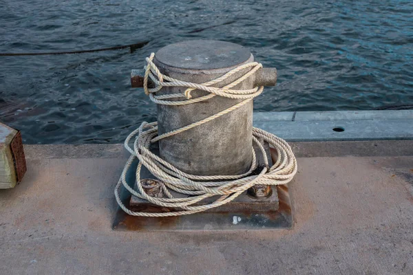 Photograph of white rope wrapped around a steel boat mooring bollard on King Island in the Bass Strait of Tasmania in Australia