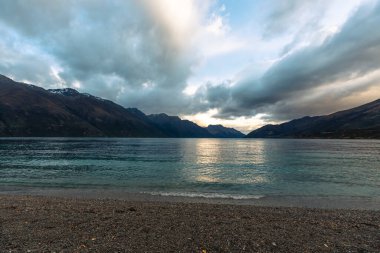 Yeni Zelanda 'nın güney adasındaki büyük bir gölü çevreleyen sıradağların fotoğrafı.