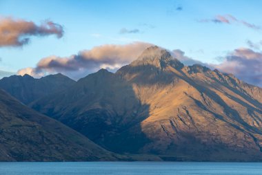 Queenstown 'daki Wakatipu Gölü' nün fotoğrafı. Yeni Zelanda 'nın güney adasında dağlar ve bulutlar.