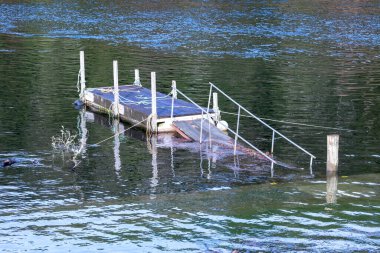 Yeni Zelanda 'nın Güney Adası' ndaki Fiordland 'daki Manapouri Kayık Kulübü' nün sel sularında demirleyen çelik tekne fotoğrafları.