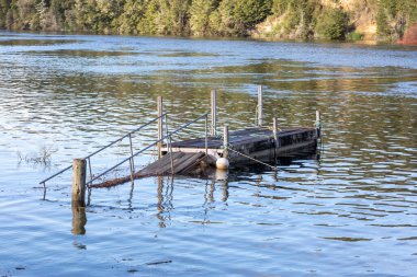 Yeni Zelanda 'nın Güney Adası' ndaki Fiordland 'daki Manapouri Kayık Kulübü' nün sel sularında demirleyen çelik tekne fotoğrafları.
