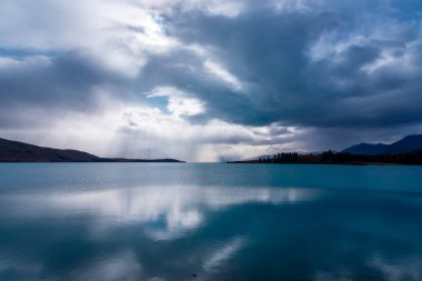 Yeni Zelanda 'nın Güney Adası' ndaki Tekapo Gölü 'nde sabah erken saatlerde parlayan güneşin fotoğrafı.