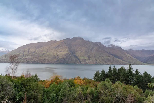 Yeni Zelanda 'nın Güney Adası Queenstown' da bulutlu bir günde Wakatipu Gölü 'ndeki bir sıradağların fotoğrafı.