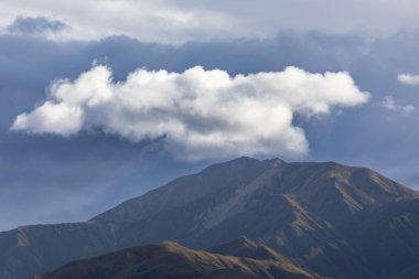 Yeni Zelanda 'nın Güney Adası' ndaki düşük seviyeli gri bulutlarla kaplı bir sıradağların fotoğrafı.