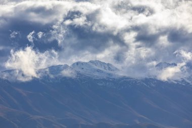 Yeni Zelanda 'nın Güney Adası' ndaki düşük seviyeli gri bulutlarla kaplı bir sıradağların fotoğrafı.