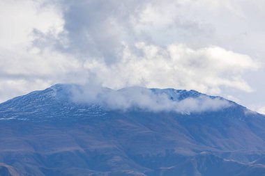 Yeni Zelanda 'nın Güney Adası' ndaki düşük seviyeli gri bulutlarla kaplı bir sıradağların fotoğrafı.