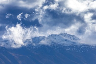 Yeni Zelanda 'nın Güney Adası' ndaki düşük seviyeli gri bulutlarla kaplı bir sıradağların fotoğrafı.