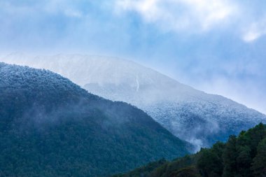 Yeni Zelanda 'nın Güney Adası' ndaki Fiordland Ulusal Parkı 'nda karlı dağlarla kaplı büyük bir vadinin fotoğrafı.