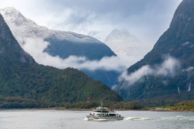 New Zealand 'ın Güney Adası' ndaki Fiordland Ulusal Parkı 'ndaki Milford Sound' da turistlerle yolculuk eden bir tur teknesinin fotoğrafı.