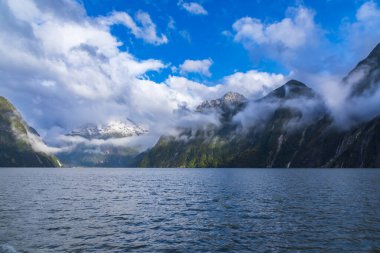Yeni Zelanda 'nın Güney Adası' ndaki Fiordland Ulusal Parkı 'nda Milford Sound' da açık mavi bir gökyüzüne karşı bir dağ sırasındaki kar fotoğrafı.