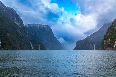 Şiddetli yağmurdan ve soğuk havadan sonra Yeni Zelanda 'nın güneyindeki Fiordland Ulusal Parkı' ndaki Milford Sound 'da Su Şelalesi' nin fotoğrafı.