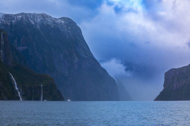 Şiddetli yağmurdan ve soğuk havadan sonra Yeni Zelanda 'nın güneyindeki Fiordland Ulusal Parkı' ndaki Milford Sound 'da Su Şelalesi' nin fotoğrafı.