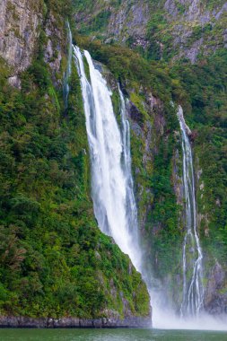Şiddetli yağmurdan ve soğuk havadan sonra Yeni Zelanda 'nın güneyindeki Fiordland Ulusal Parkı' ndaki Milford Sound 'da Su Şelalesi' nin fotoğrafı.