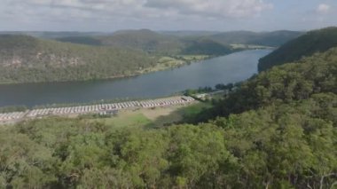 Hawkesbury Nehri ve Koveda Holiday Parkı 'ndan Avustralya' nın New South Wales kentindeki Wisemans Feribotu yakınlarındaki Hawkins Gözcüleri 'ne geri çekilen insansız hava aracı görüntüleri..