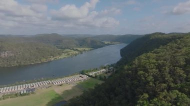 Avustralya 'nın Yeni Güney Galler kentindeki Wisemans Feribotu yakınlarındaki Hawkesbury Nehri' ndeki etkileyici Koveda Holiday Parkı 'nın solundaki insansız hava aracı görüntüleri..