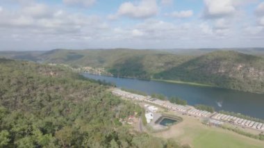 Avustralya 'nın Yeni Güney Galler kentindeki Wisemans Feribotu yakınlarındaki Hawkesbury Nehri' ndeki etkileyici Koveda Holiday Parkı 'nın solundaki insansız hava aracı görüntüleri..