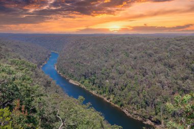 Photograph of the Nepean River under a cloudy orange sky from The Rock Lookout observation point in the Blue Mountains in New South Wales, Australia. clipart