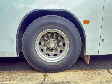 Photograph of a passenger bus tyre and rim that has been well used and indicates the high work load of public transportation vehicles.