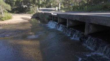 Megalong Creek 'in Megalong Yolu' nun altından akan görüntüler Avustralya 'nın NSW kentindeki Mavi Dağlar' daki Megalong Vadisi 'ndeki eski Ford Reserve kamp alanının yakınında..