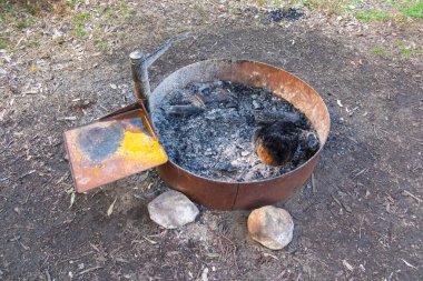 Çelik halkalı kamp ateşi kuyusu, orman yangını tehlikesi altındaki büyük bir ormanda ısıtma ve pişirme için güvenli bir kullanım sağlamak amacıyla yapılmış..