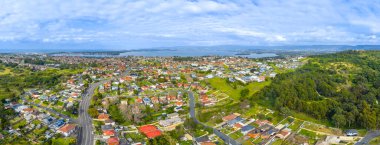 Avustralya, New South Wales 'in güney kıyısındaki Illawarra bölgesinde Illawarra Gölü' nün arka planında Illawarra Gölü ile Lake Heights banliyösünün insansız hava aracı panoramik fotoğrafı..