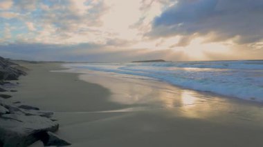 Pasifik Okyanusu 'ndan gelen dalgaların sesi duyulmayan görüntüler Avustralya' nın Yeni Güney Galler 'in güneyindeki Illawarra bölgesinde Warilla kasabası yakınlarındaki kayalık bir kıyı şeridine giriyor..