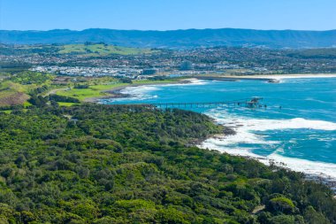 Avustralya, Yeni Güney Galler 'in güney kıyısındaki Illawarra bölgesinde, Güney Pasifik Okyanusu yakınlarında eski ve yıpranmış bir endüstriyel yükleme iskelesinin insansız hava aracı fotoğrafı..