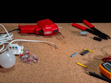 Lehim yapma - kabloları teneke ve lehimleme demiriyle birleştirme, atölye, arka plandaki elektrik elementleri, kablolar
