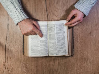 Caen, France 2023. Man reading an old book top view, wooden table