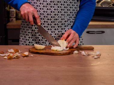 Aşçı odun kesme tahtasıyla soğan doğruyor. Yakın çekim..